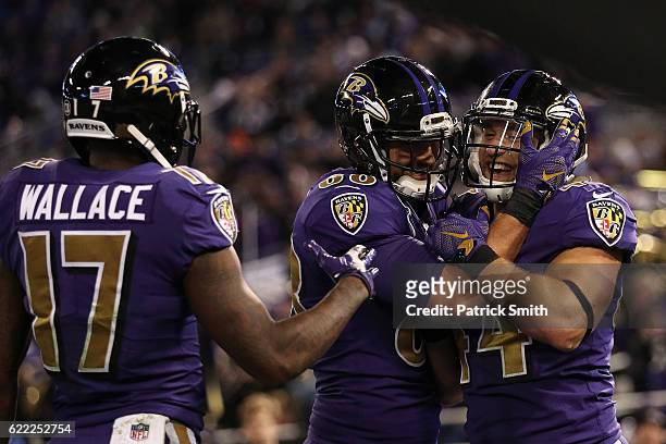 Fullback Kyle Juszczyk of the Baltimore Ravens celebrates with teammates tight end Dennis Pitta and wide receiver Mike Wallace after scoring a...