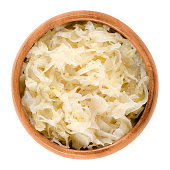 German sauerkraut in wooden bowl over white