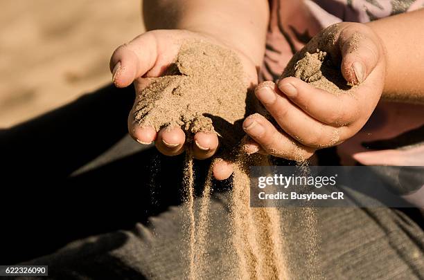 sand running through fingers - sifting stock pictures, royalty-free photos & images