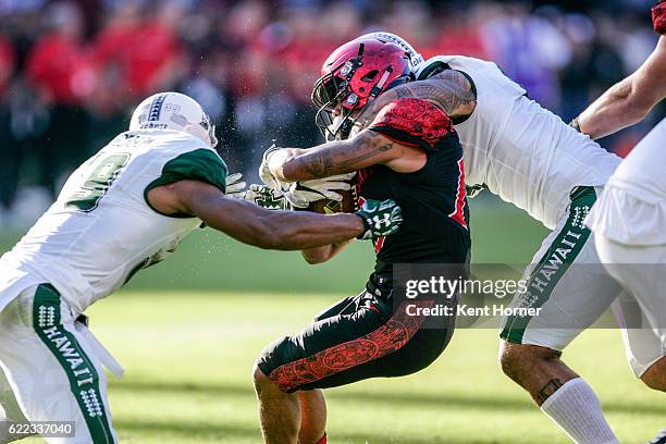 Donnel Pumphrey of the San Diego State Aztecs is tackled running with the ball in the first half against the Hawaii Rainbows in Qualcomm Stadium on...