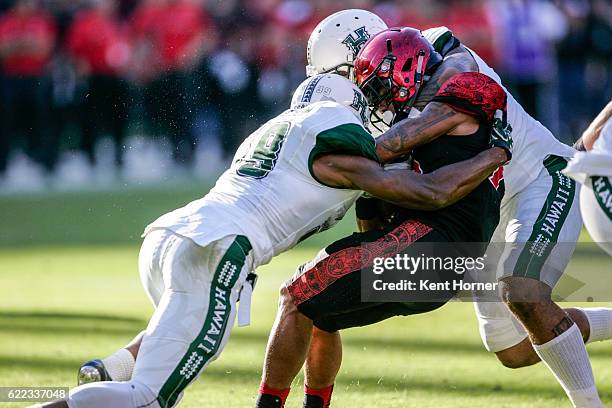 Donnel Pumphrey of the San Diego State Aztecs is tackled running with the ball in the first half against the Hawaii Rainbows in Qualcomm Stadium on...