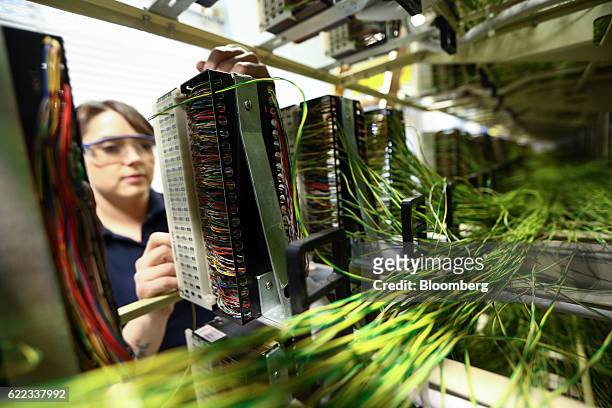 Network engineer from Openreach, a unit of BT Group Plc, works on copper jumper wires inside an exchange building in this arranged photograph in...