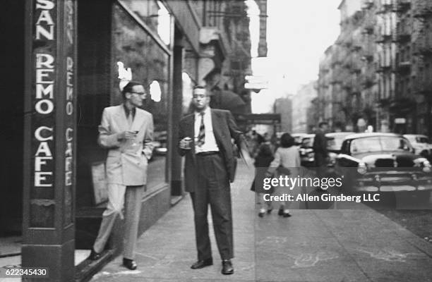 William S. Burroughs and Alan Ansen chat on the sidewalk outside the San Remo Cafe in Greenwich Village.