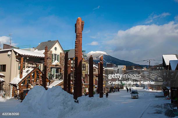 Street scene with carved wooden Ainu poles in Ainu Kotan, which is a small Ainu village in Akankohan, a street lined by souvenir shops specializing...