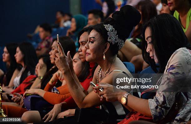 Transvestite spectators attend the 2016 Miss Queen contest in Jakarta on November 11, 2016. Indonesian transgenders paraded in colorful, glittering...