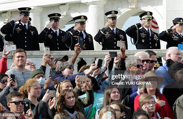 Visitors and military watch as US President Barack Obama participates in a wreath-laying ceremony at the Tomb of the Unknown Soldier at Arlington...