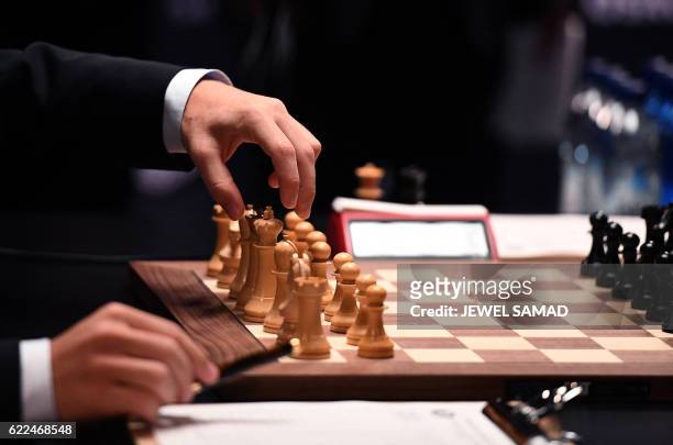 Chess grandmaster and current world chess champion Magnus Carlsen of Norway moves a piece on the board against challenger Sergey Karjakin of Russia...