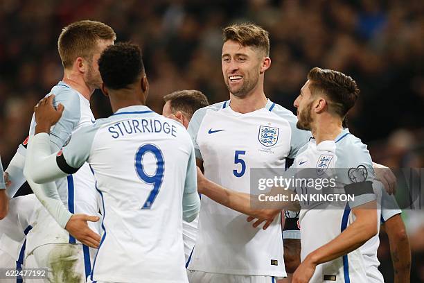 England's defender Gary Cahill celebrates with teammates after scoring their third goal during a World Cup 2018 qualification match between England...