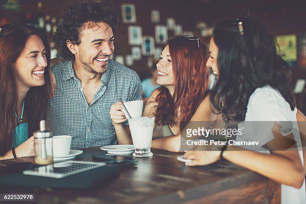 three girls and one man in cafe - man met een groep vrouwen stockfoto's en -beelden