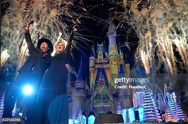 In this handout photo provided by Disney Parks, Country music stars Trisha Yearwood and Garth Brooks perform during the taping of the ABC and Disney...