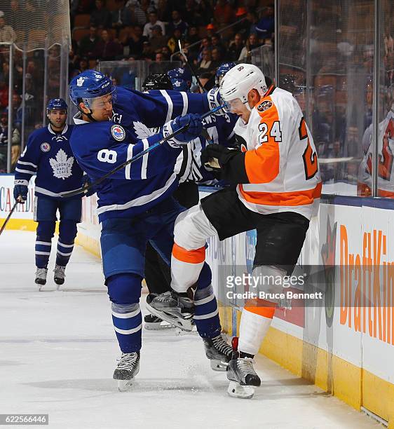Connor Carrick of the Toronto Maple Leafs checks Matt Read of the Philadelphia Flyers during the third period at the Air Canada Centre on November...