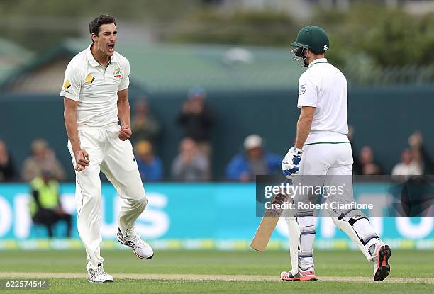 Mitchell Starc of Australia celebrates after taking the wicket of Stephen Cook of South Africa during day one of the Second Test match between...