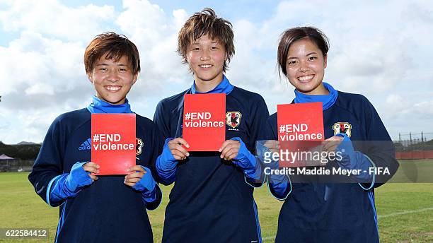 Port Moresby, PNG Yuka Momiki of Japan, Ruka Norimatsu, and Yui Hasegawa hold cards supporting the #ENDviolence campaign during a training session in...