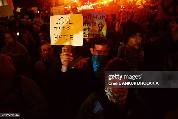 Demonstrator holds up a placard during a protest against Donald Trump's US presidential election victory, at City Hall in Portland on November 11,...