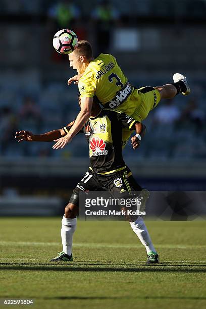 Scott Galloway of Mariners jumps over the top of Roy Krishna of the Phoenix to head the ball during the round six A-League match between the Central...