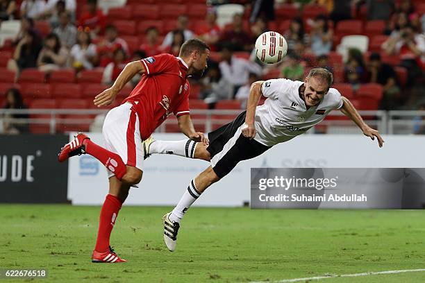 Alexander Zickler of Germany heads the ball under pressure from Luke Young of England during the Battle of Europe match between England Masters and...