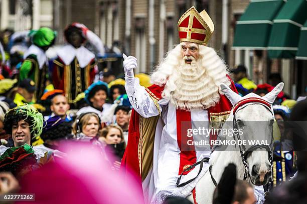 Man dressed as Sinterklaas gestures as he arrives on a horse in Maassluis on Novermber 12, 2016. Black Pete is the companion of Saint Nicolas during...