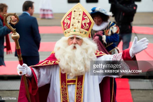 Man dressed as Sinterklaas follwoed by another one dressed as Zwarte Piet gestures as he arrives on November 12, 2016 in Antwerp. - Black Pete is the...