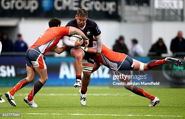 Richard Barrington of Saracens is tackled by Mouritz Botha and Sam Egerton of Newcastle Falcons during the Anglo-Welsh Cup between Saracens and...