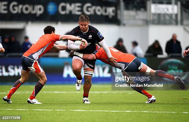 Richard Barrington of Saracens is tackled by Mouritz Botha and Sam Egerton of Newcastle Falcons during the Anglo-Welsh Cup between Saracens and...