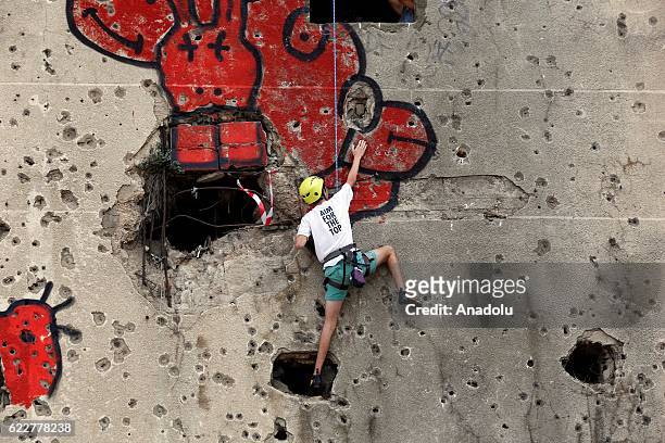 People taking part in the competition, held in the Bishara El Huri region of the capital Beirut, try to climb the entire wall using holes created in...