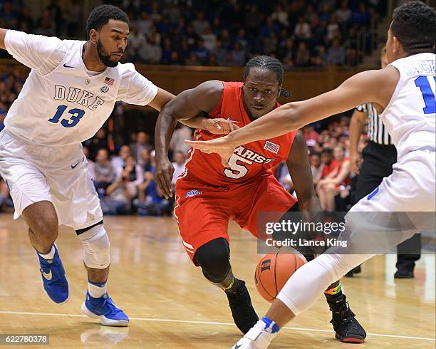 Khallid Hart of the Marist Red Foxes moves the ball against Matt Jones and Frank Jackson of the Duke Blue Devils at Cameron Indoor Stadium on...