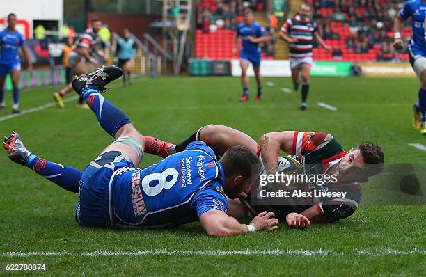 Owen Williams of Leicester Tigers slides over the line ahead of Harri Keddie of Newport Gwent Dragons to score the opening try during the Anglo-Welsh...