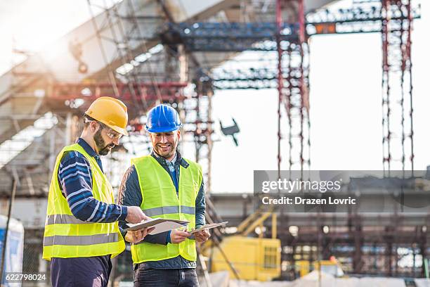 teamarbeit auf der baustelle beim brückenbau - bauingenieurwesen stock-fotos und bilder