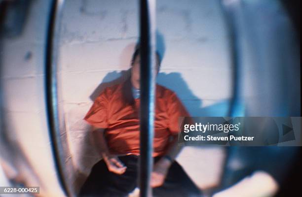 prisoner behind bars of cell - häftling stock-fotos und bilder