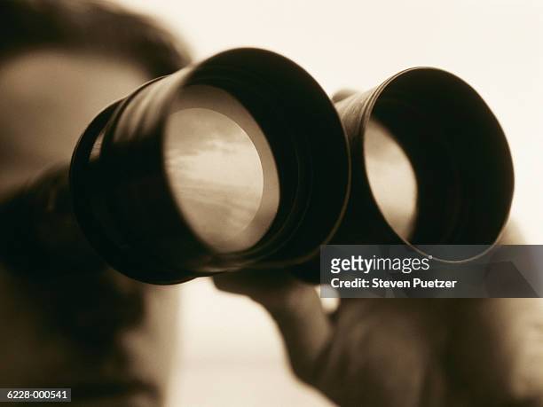 man looking through binoculars - canocchiale foto e immagini stock