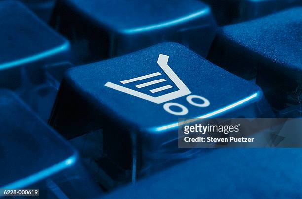 shopping cart on keyboard - online shop stockfoto's en -beelden