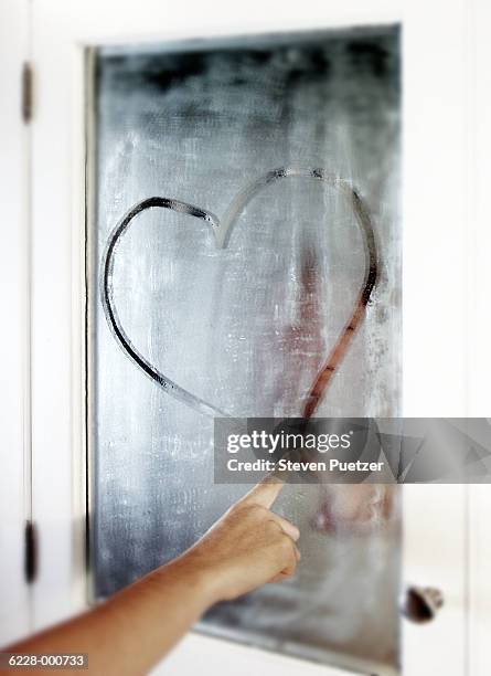 young woman drawing a heart - mirror steam stockfoto's en -beelden