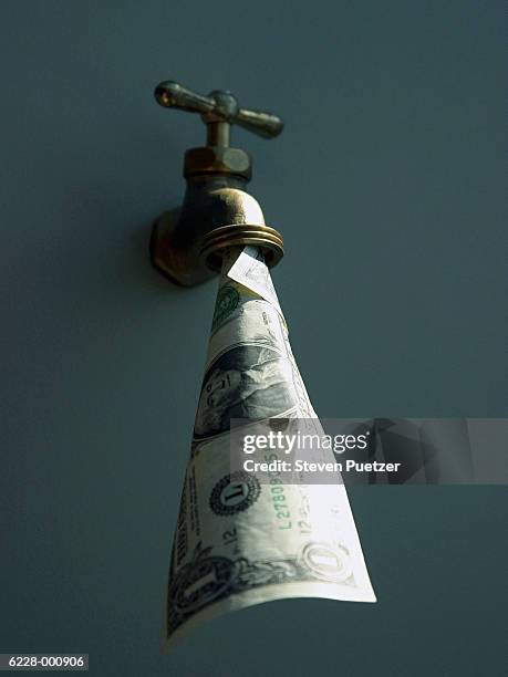 dollar bill in faucet - geldfluss stock-fotos und bilder