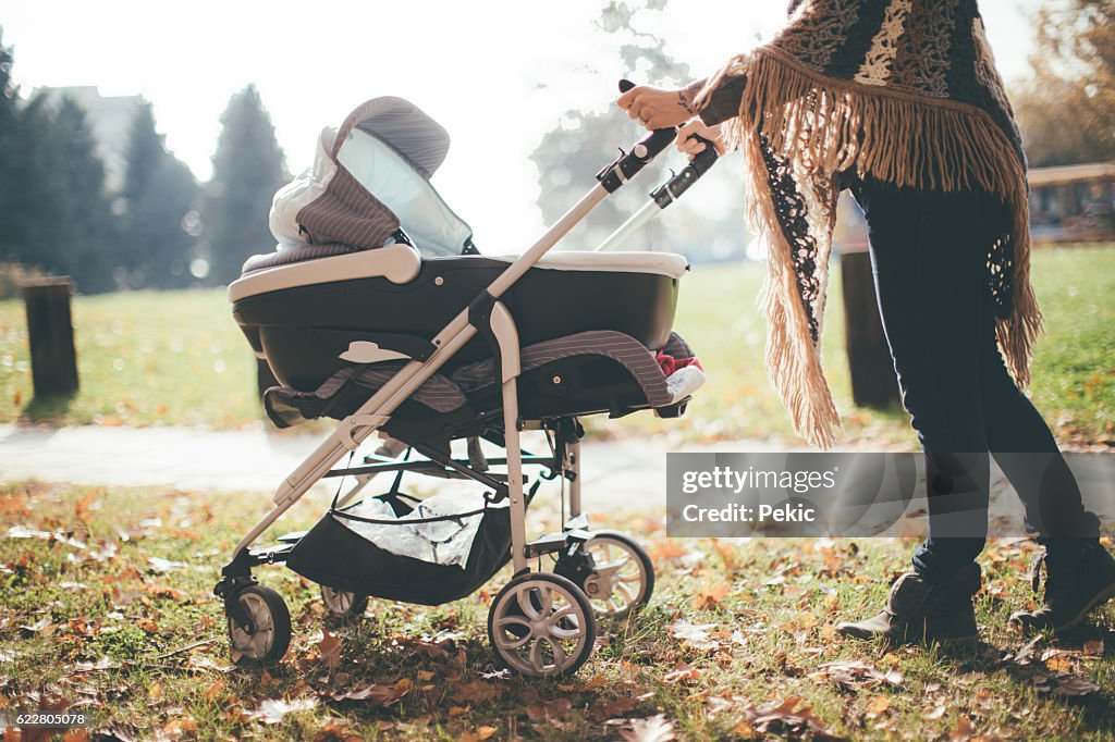 Jovem mãe com um carrinho de bebê