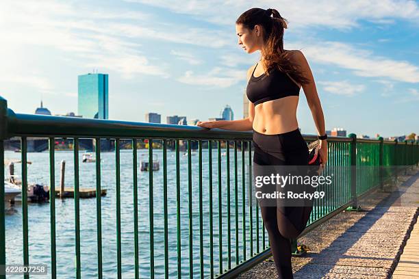 female runner stretching beim genießen der aussicht in boston, usa - damen leichtathletikdisziplin stock-fotos und bilder