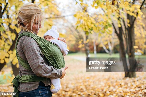 newborn in baby sling carrier - woman in a shawl stock pictures, royalty-free photos & images