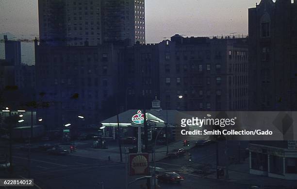 Amoco and Shell gas stations on a street corner in the Bronx, New York City, New York, with apartment buildings visible, 1976. .