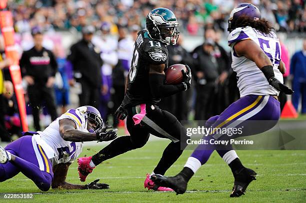 Safety Jayron Kearse of the Minnesota Vikings, left, can't hang onto wide receiver Josh Huff of the Philadelphia Eagles as middle linebacker Eric...