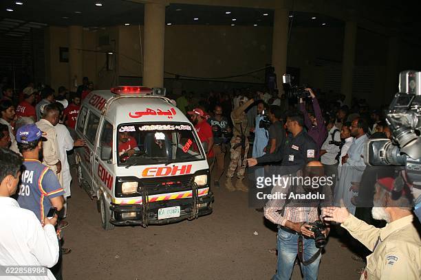 Pakistani rescue workers and volunteers unload an injured victim of bomb blast, from an ambulance upon his arrival at a local hospital in Hub town...