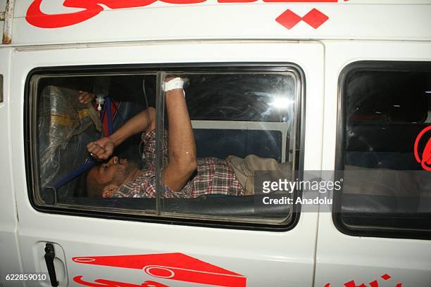 Pakistani rescue workers and volunteers unload victims of bomb blast, from an ambulance upon his arrival at a local hospital in Hub town near...