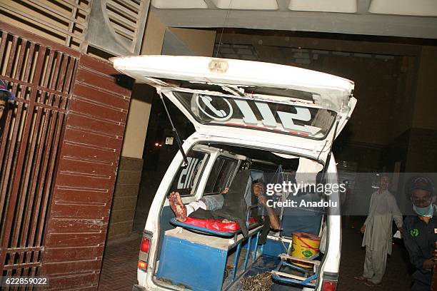 Pakistani rescue workers and volunteers unload victims of bomb blast, from an ambulance upon his arrival at a local hospital in Hub town near...