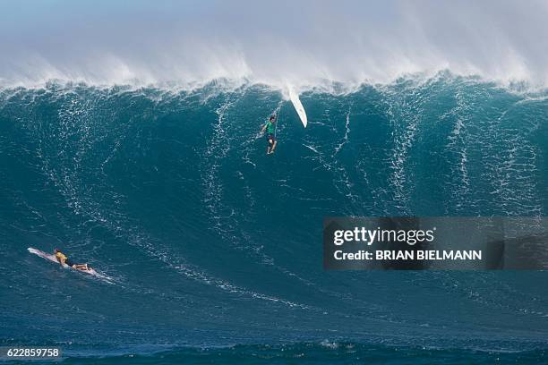 Surfer is wiped out by a big wave as another one paddles out to escape it during the Big Wave surfing Peahi Challenge 2016 at Jaws, off the coast of...