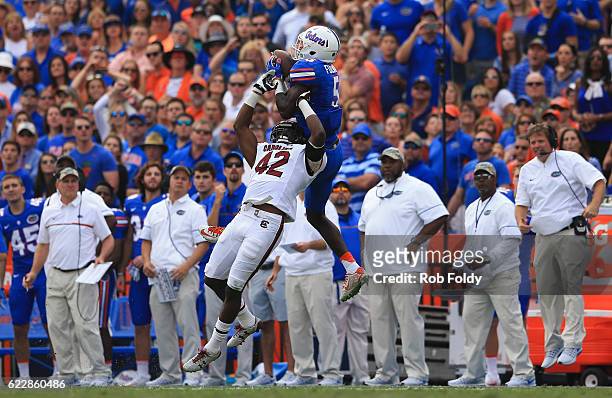 Ahmad Fuelwood of the Florida Gators makes a catch over Jordan Diggs of the South Carolina Gamecocks as head coach Jim McElwain of the Florida...