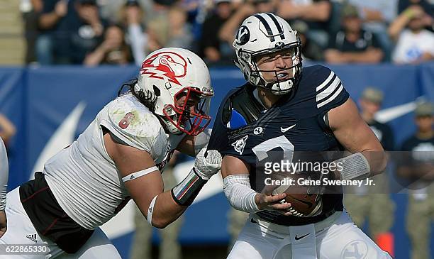 Quarterback Taysom Hill of the Brigham Young Cougars is pressured by Taylor Pili of the Southern Utah Thunderbirds in the first half at LaVell...