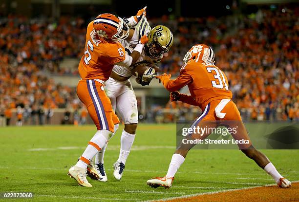 Teammates Dorian O'Daniel and Ryan Carter of the Clemson Tigers try to stop James Conner of the Pittsburgh Panthers during their game at Memorial...