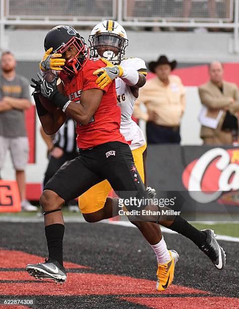Defensive back Jericho Flowers of the UNLV Rebels catches a touchdown pass in the first overtime against cornerback Rico Gafford of the Wyoming...