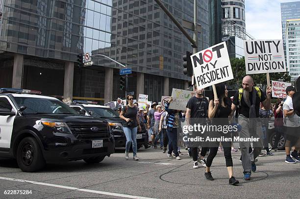 Demonstrators walk in front of police as thousands of people protest in the streets against President-elect Donald Trump on November 12, 2016 in Los...