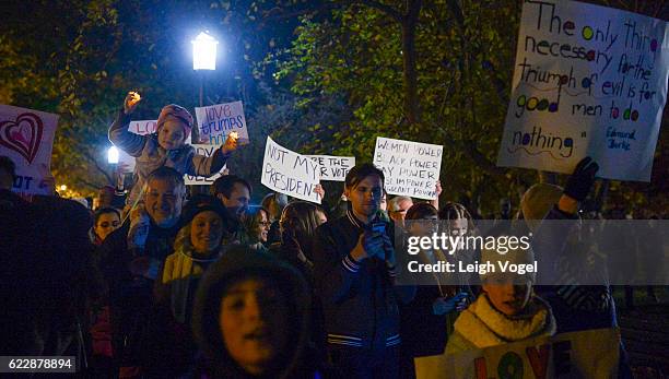 Falls Church, VA resident Jeff Keas carries his five-year old daughter Juliana Keas on his shoulders during a protest against election results next...