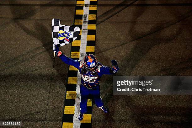 Kyle Busch, driver of the NOS Energy Drink Toyota, celebrates with the checkered flag after winning the NASCAR XFINITY Series Ticket Galaxy 200 at...
