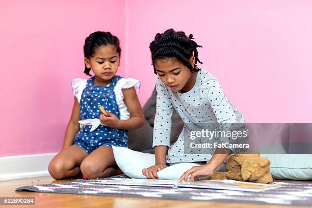 sœurs afro-américaines lisant un livre et mangeant des collations - fat twins photos et images de collection